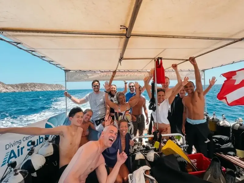 Groupe de plongeurs joyeux sur un bateau en mer, équipement visible