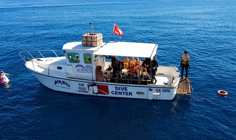 Bateau de plongée avec des plongeurs préparant une sortie en mer