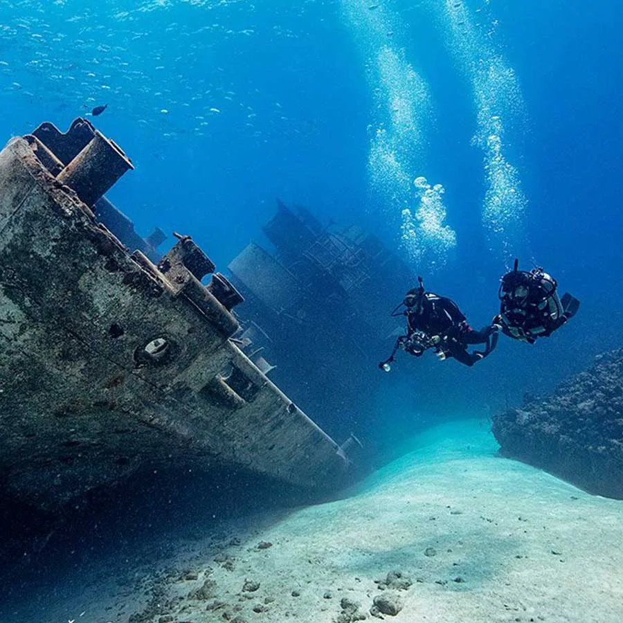 Deux plongeurs explorent l'épave d'un navire sous-marin, lumière divine