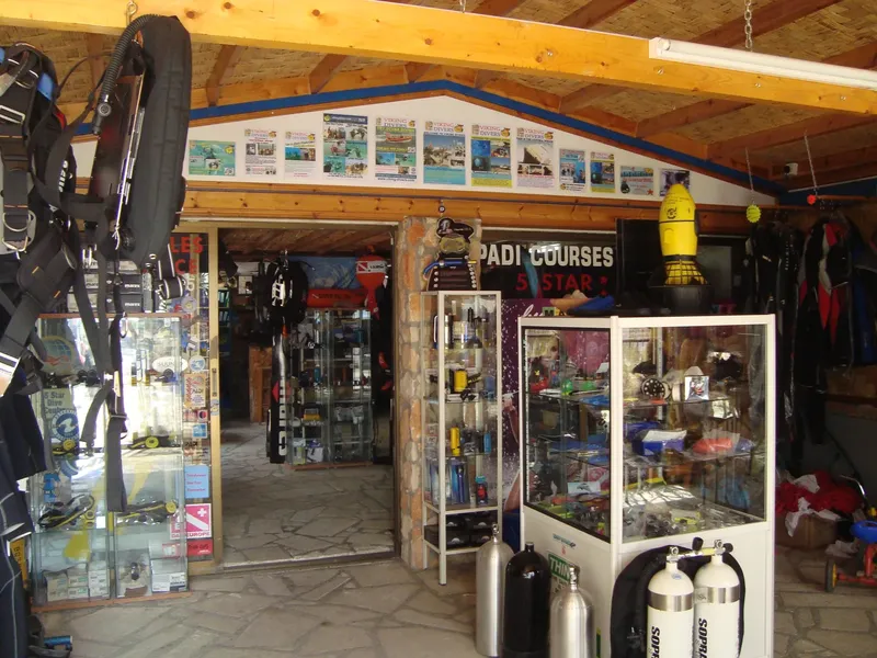 Intérieur d'un centre de plongée avec matériel, vitrines et affiches PADI