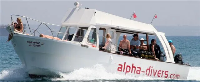 Bateau de plongée blanc avec des passagers et du matériel à bord
