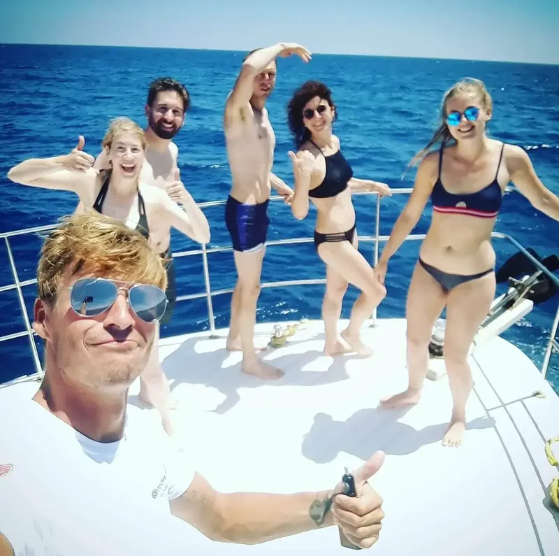 Groupe de personnes souriantes sur un bateau en mer, ambiance joyeuse
