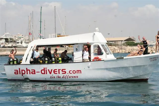 Bateau de plongée blanc avec des plongeurs et le nom du centre