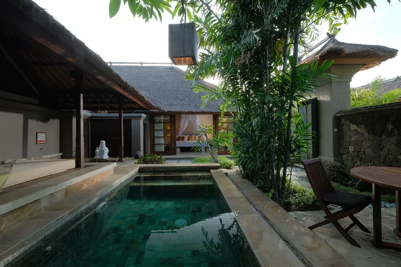 Cour intérieure avec piscine, bâtiments traditionnels et végétation tropicale