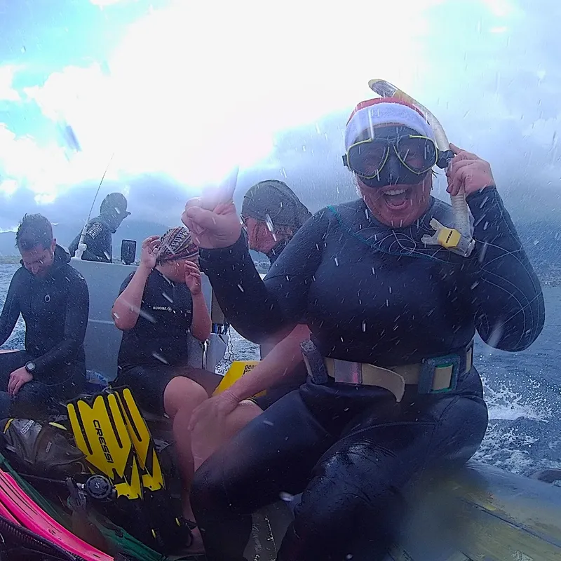 Plongeurs en combinaison sur un bateau, préparant leur matériel de plongée