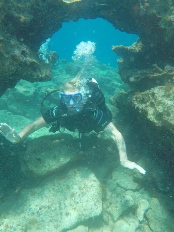 Plongeur explore une grotte sous-marine avec une visibilité claire