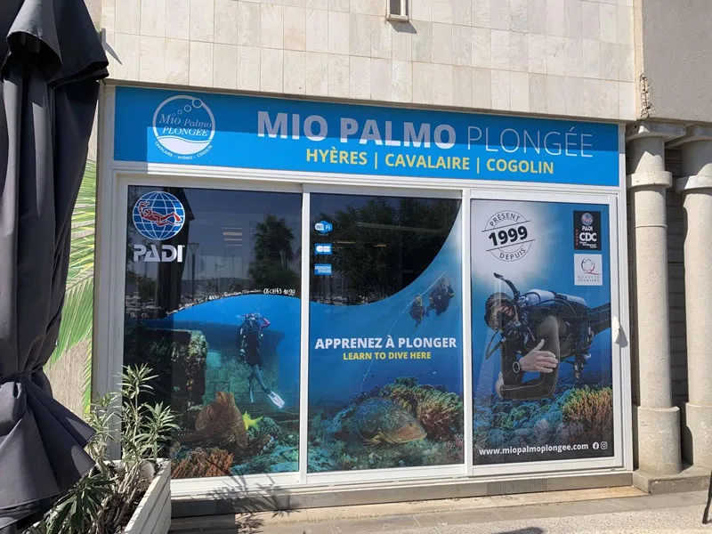 Devanture d'un centre de plongée avec vitrine décorée de scènes sous-marines