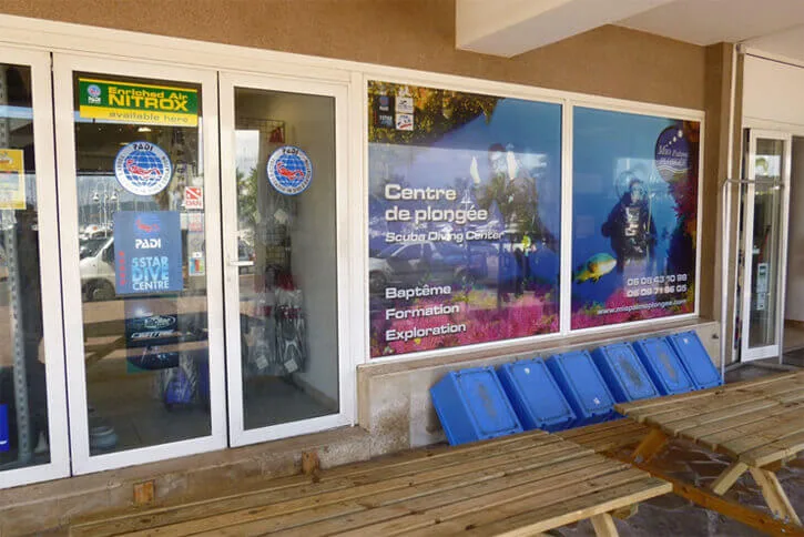 Vitrine d'un centre de plongée avec affiches et matériel visible