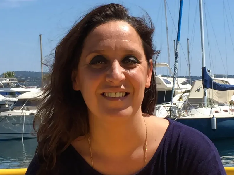 Portrait souriant d'une femme devant des bateaux amarrés au port
