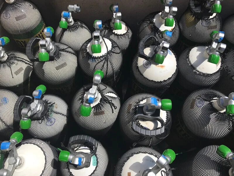 Bouteilles de plongée noires protégées par des filets, prêtes à l'utilisation