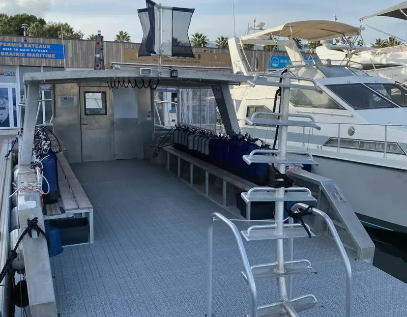 Bateaux de plongée amarrés à un ponton avec des bouteilles bleues