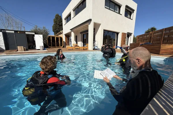 Formation plongée en piscine avec instructeur et participants équipés