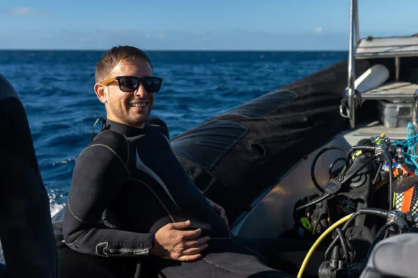 Plongeur souriant en combinaison sur un bateau de plongée en mer