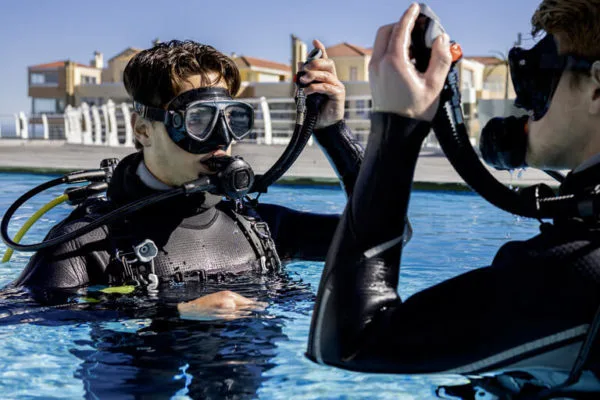 Deux plongeurs en formation vérifient l'équipement dans une piscine