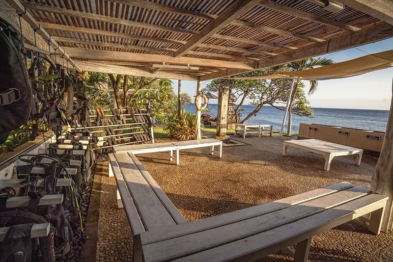 Espace de préparation plongée avec matériel, bancs et vue sur mer