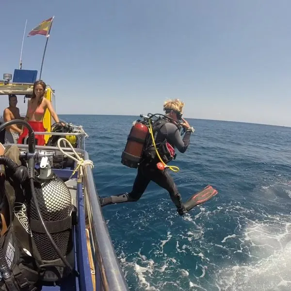 Plongeur s'apprête à sauter d'un bateau en pleine mer