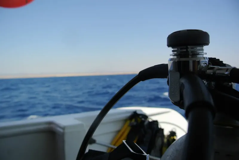 Bateau de plongée en mer, détendeur et tuyau au premier plan