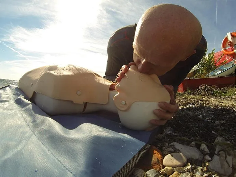 Homme effectuant un massage cardiaque sur un mannequin de premiers secours
