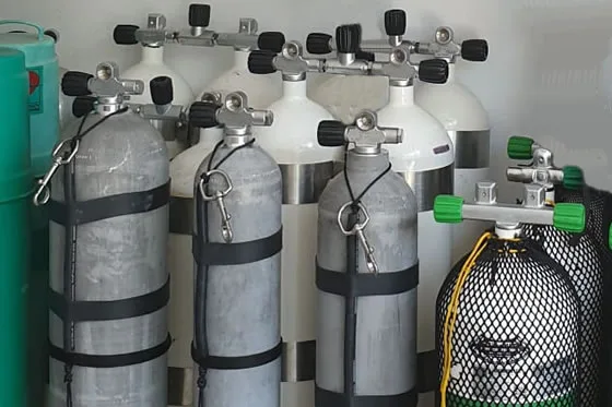 Rangée de bouteilles de plongée avec détendeurs et sangles noires