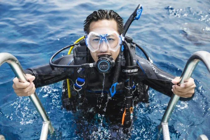 Plongeur équipé se prépare à entrer dans l'eau depuis un bateau