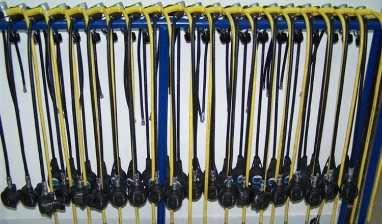 Rangée de détendeurs noirs et tuyaux jaunes sur un support bleu
