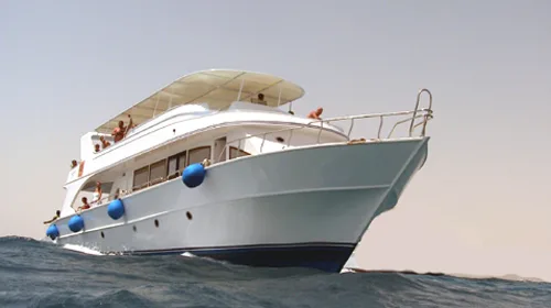 Bateau de plongée blanc avec des passagers sur le pont en mer