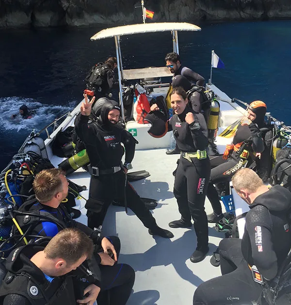 Plongeurs équipés sur un bateau pneumatique en préparation de plongée