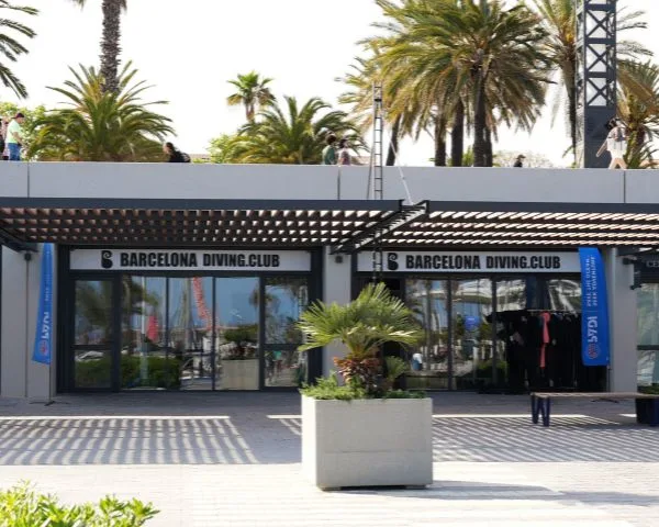 Façade d'un centre de plongée avec des combinaisons et des palmes visibles