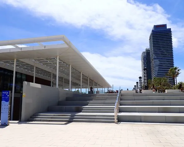 Escaliers menant à une structure moderne avec des personnes et un ciel bleu