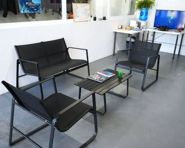 Espace détente avec canapés noirs, table basse et plantes vertes