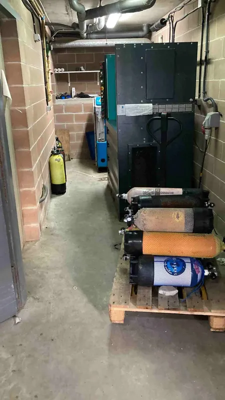 Bouteilles de plongée et compresseur dans un local technique sombre