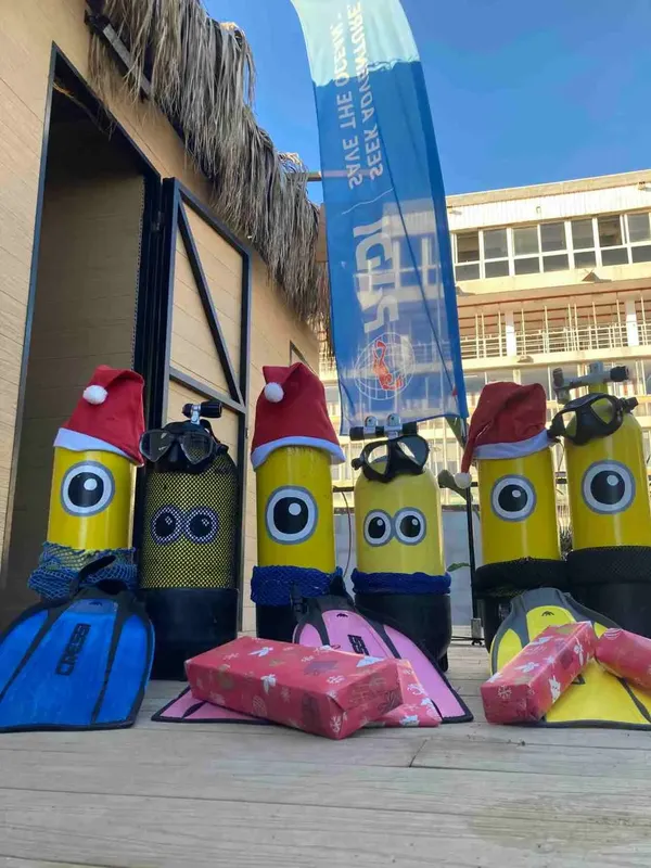 Bouteilles de plongée habillées de costumes de Noël avec des cadeaux