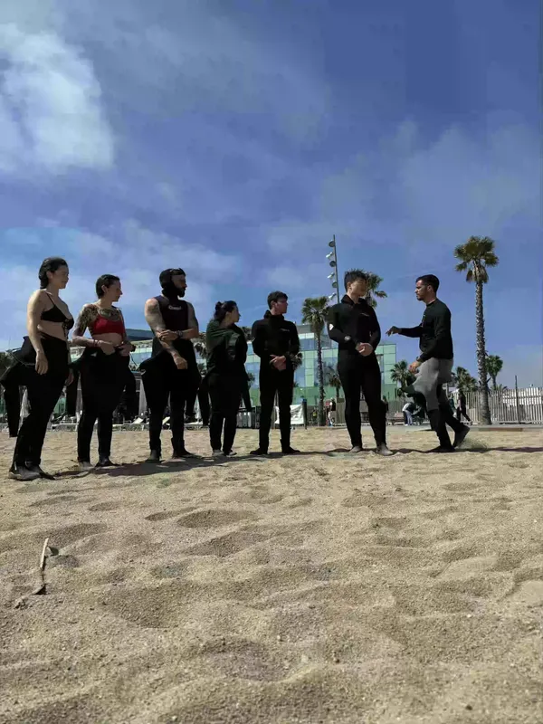Groupe de personnes sur une plage de sable, discussion et préparation