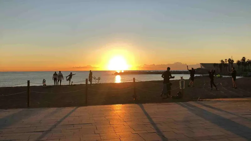 Groupe de personnes sur une plage au coucher du soleil