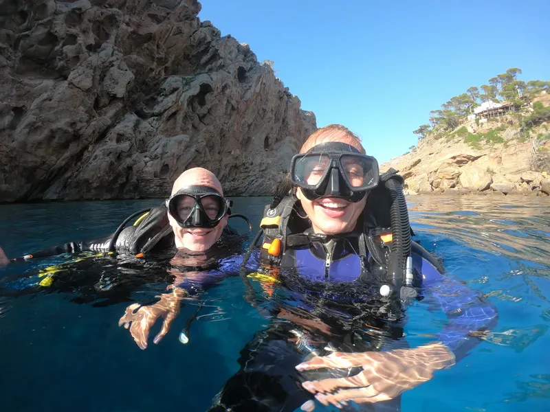 Deux plongeurs souriants avec masques et détendeurs en mer