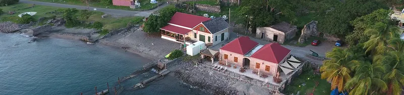 Vue aérienne d'un centre de plongée avec bâtiments et accès à la mer