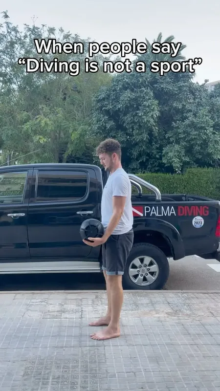 Un homme pieds nus tient un masque de plongée près d'un pick-up