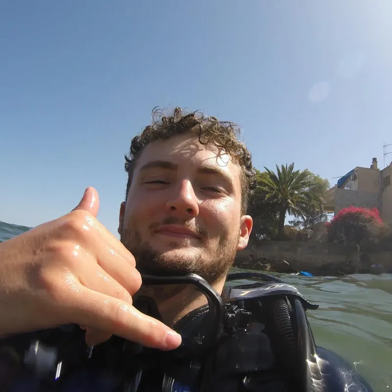 Plongeur souriant fait un signe de paix sur le bateau