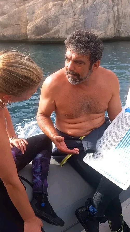 Deux personnes discutent à bord d'un bateau de plongée en mer