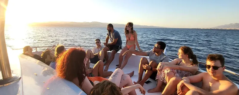 Groupe de personnes souriantes se relaxant sur un bateau en mer