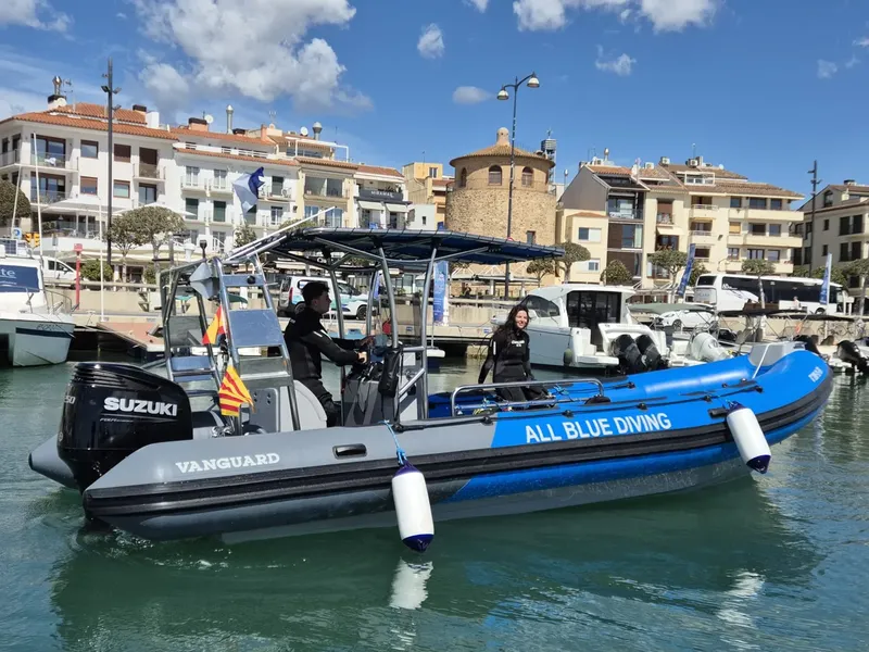 Bateau semi-rigide amarré dans un port ensoleillé avec deux personnes à bord
