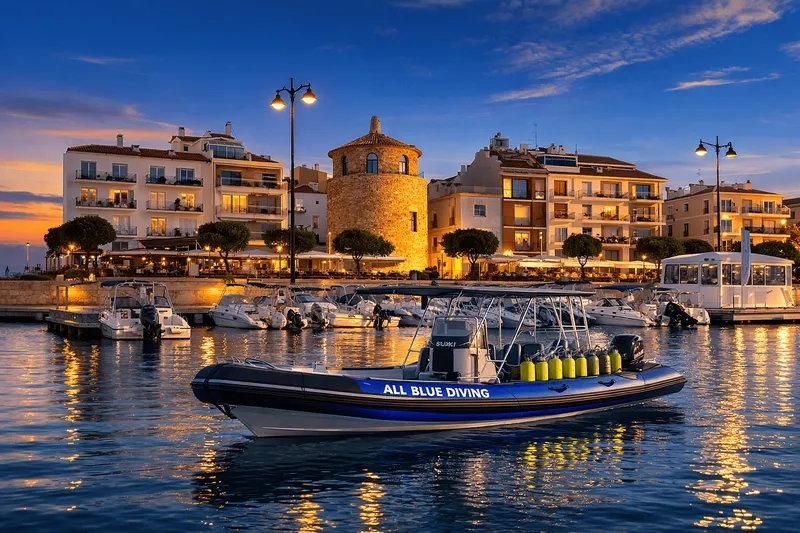 Bateau de plongée amarré dans un port au coucher du soleil