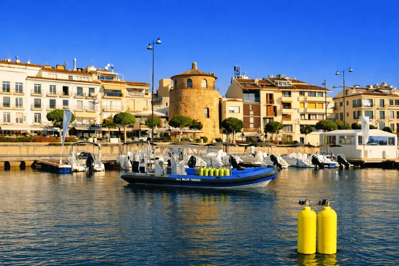 Port de plaisance avec bateau de plongée et bouteilles jaunes visibles