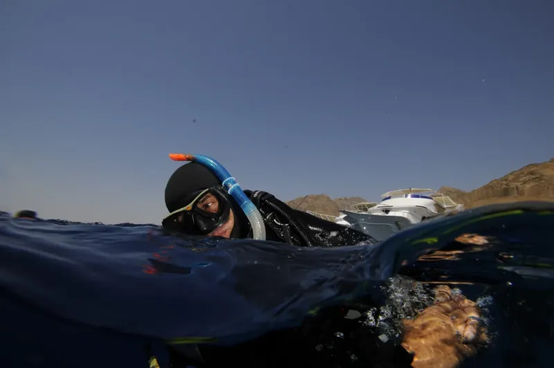Plongeur en surface nageant avec masque et tuba en mer bleue