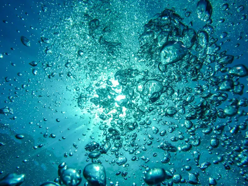 Bulles d'air remontant vers la surface dans l'eau turquoise