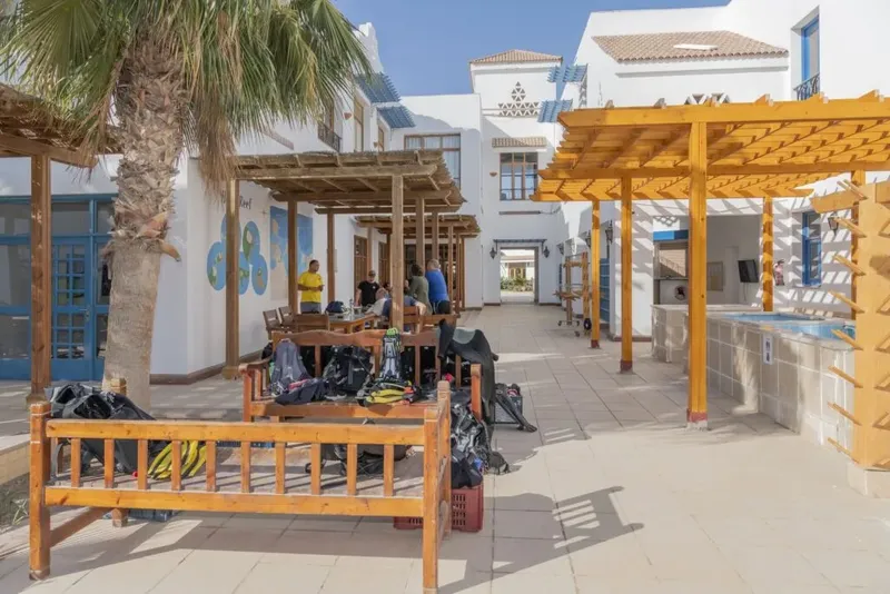 Cour intérieure d'un centre de plongée avec du matériel et des personnes