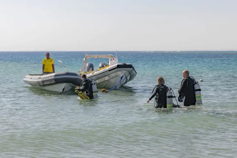 Plongeurs équipés s'apprêtent à partir en mer avec un semi-rigide