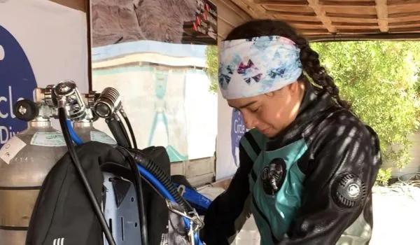 Plongeuse préparant son équipement de plongée dans un centre