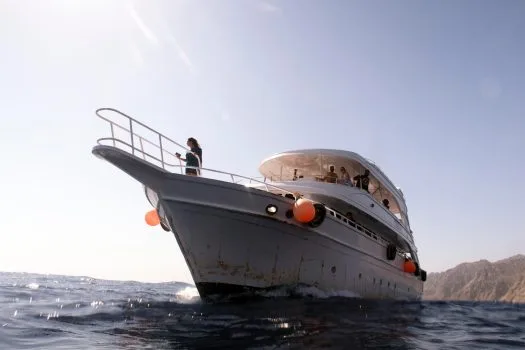 Bateau de plongée blanc avec des passagers, navigation en mer calme