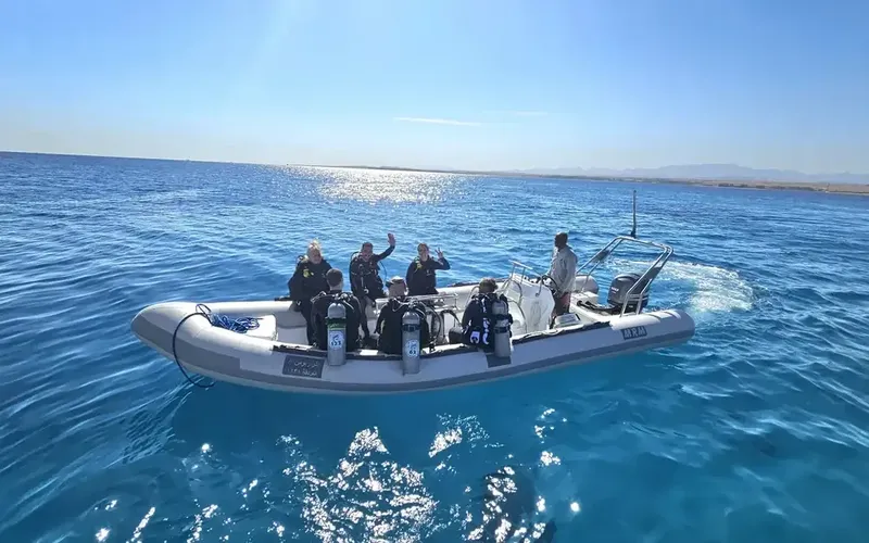 Groupe de plongeurs à bord d'un bateau semi-rigide en mer